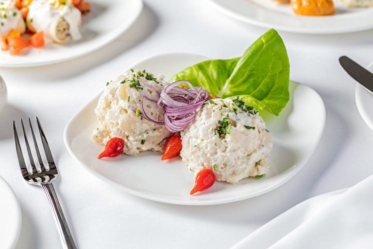 A white plate of Mesón Sabika’s garlic potato salad