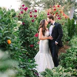A couple embracing among tall flowering garden borders