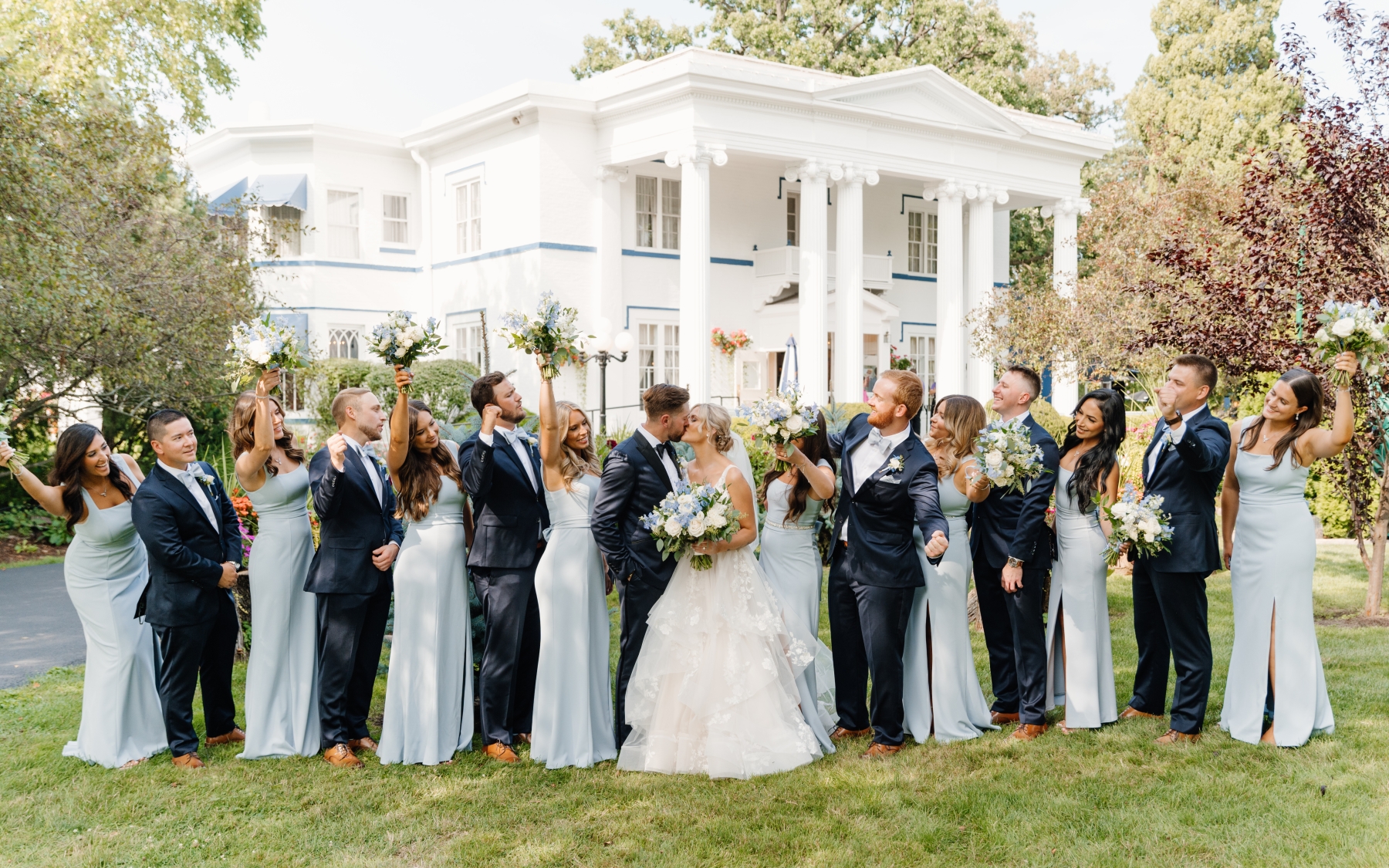 The full wedding party outside the white mansion