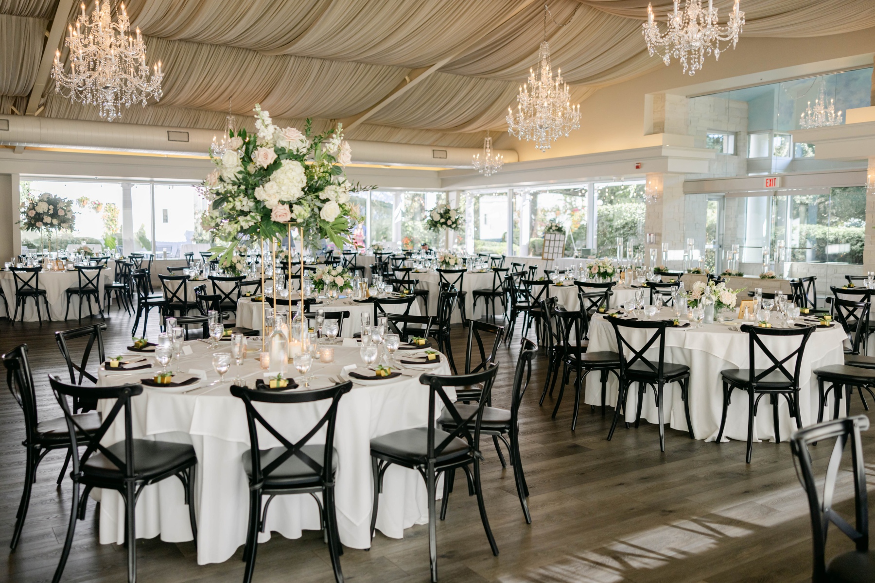 Tall floral centrepieces on round tables in the Pavilion