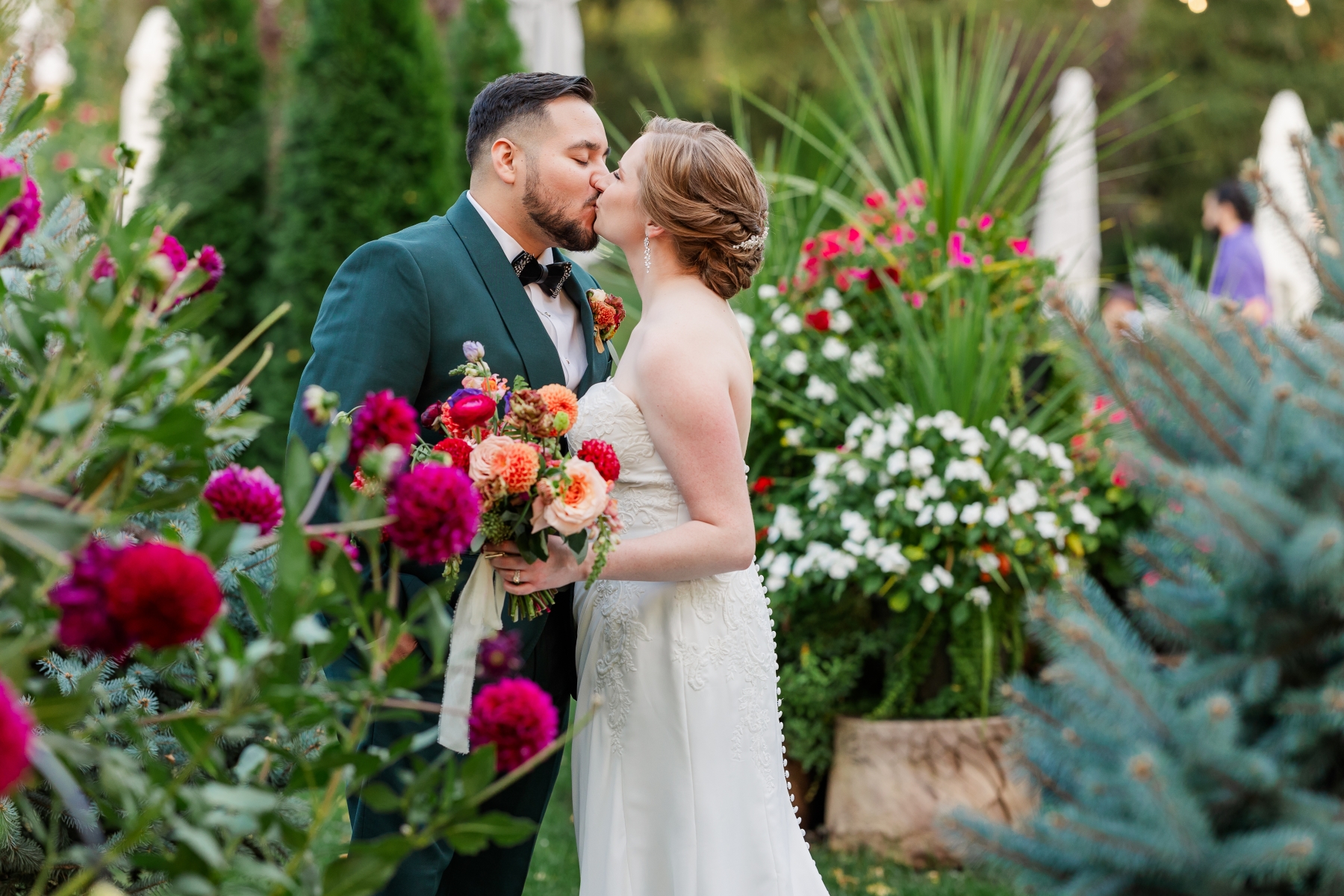 A couple kissing among the estate flower beds