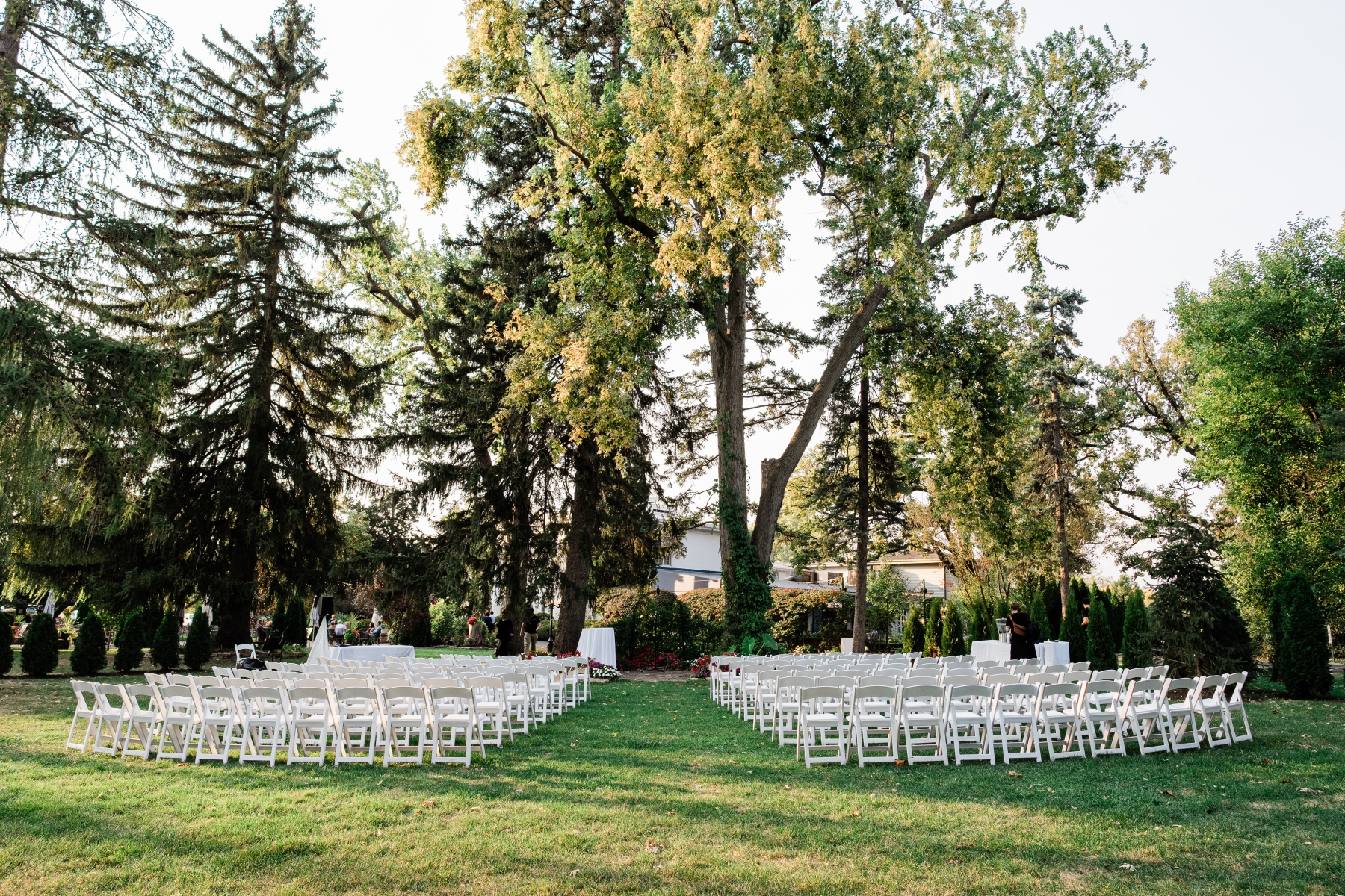 Rows of white chairs set for a ceremony on the lawn