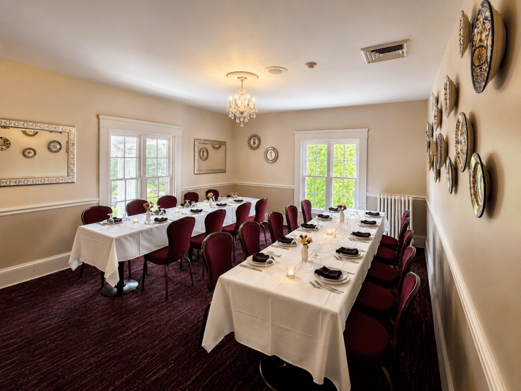 A mansion dining room set with white linen and a chandelier