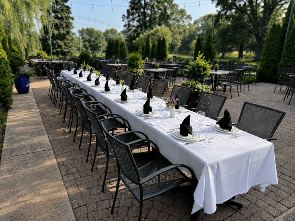 The Front Patio, a long table on brick beneath the trees